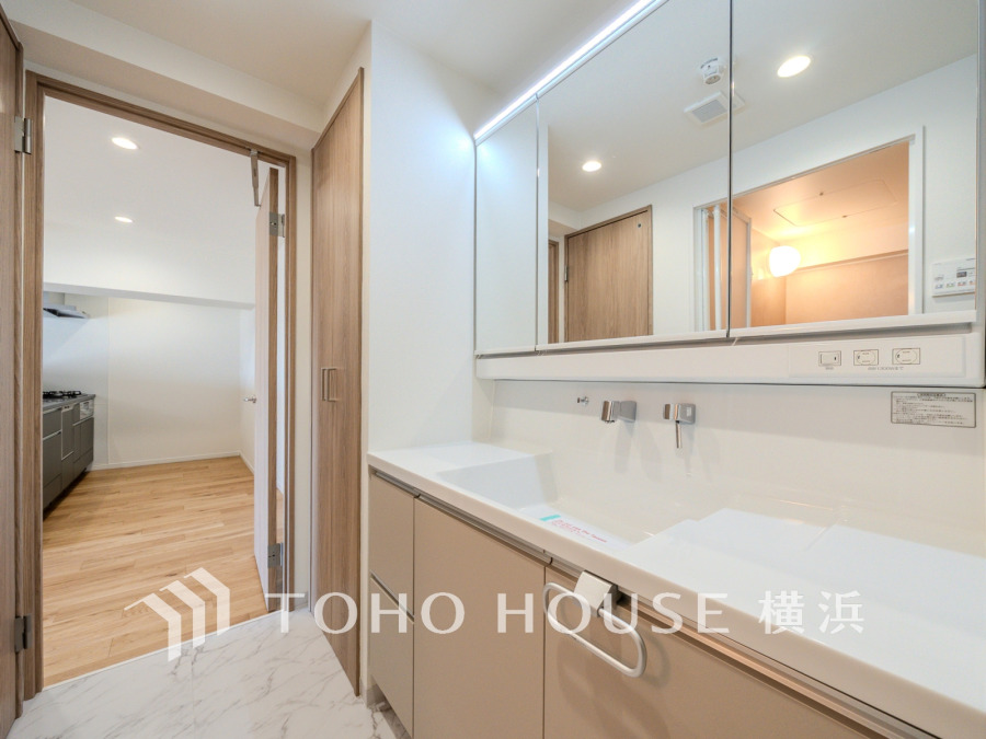 新規交換された洗面化粧台は美しく使いやすい機能が備えられています。キッチンへの動線も良好です。