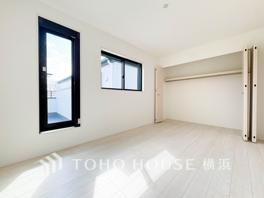 明るい光が差し込む広々とした洋室。大容量クローゼットとバルコニーに続くドアで快適な生活空間を実現。