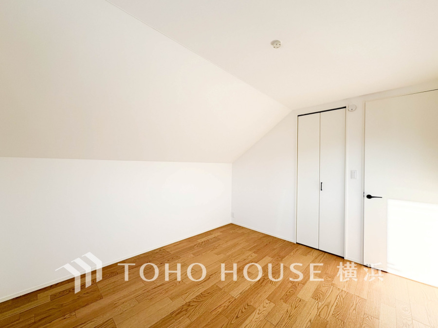 白を基調とした明るく清潔感のある洋室。斜め天井が個性的な空間を演出します。収納も備えています。