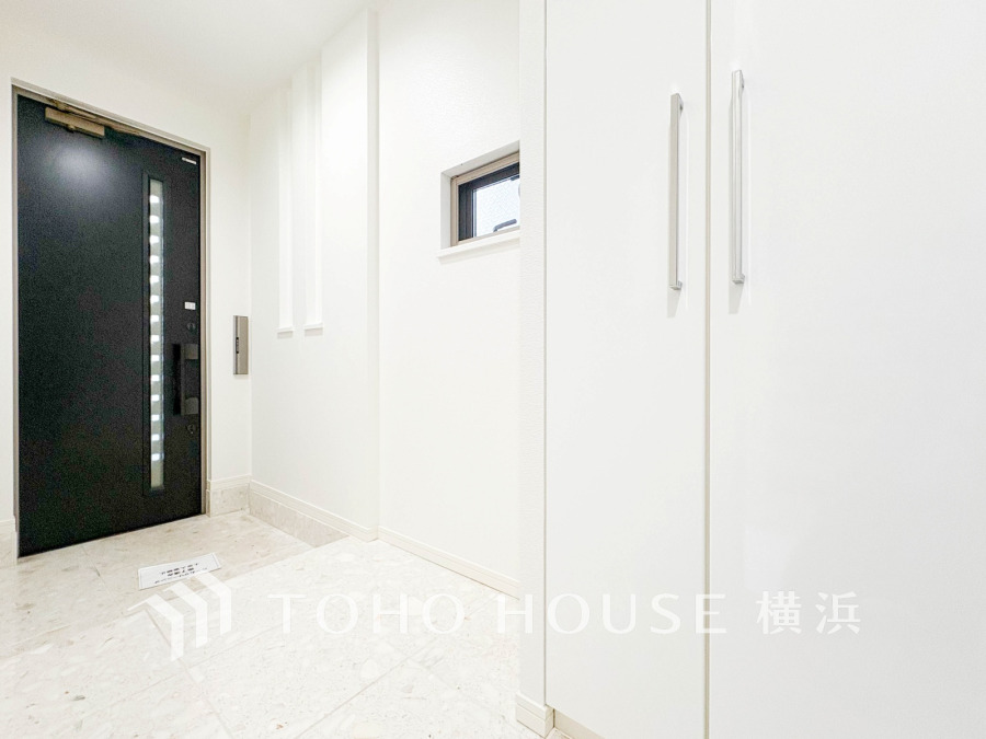 清潔感あふれるホワイトを基調とした玄関は、収納力のあるシューズボックスと採光窓で明るく広々とした空間です。