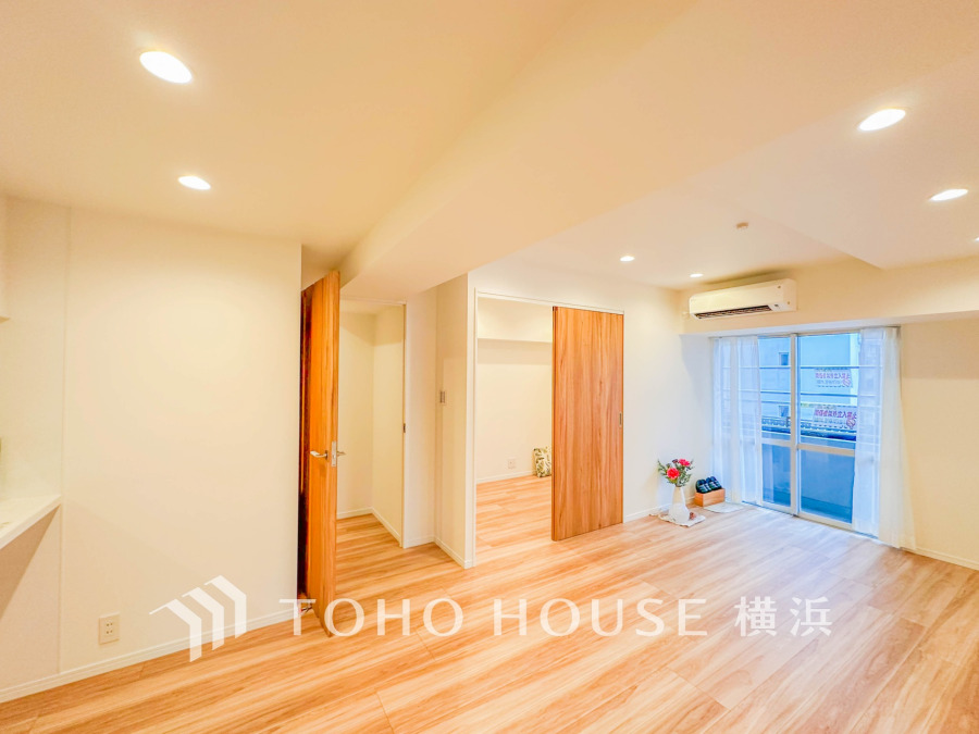 自然光が差し込む広々リビング。木目調の床と白壁で温かみのある快適な空間が広がります。