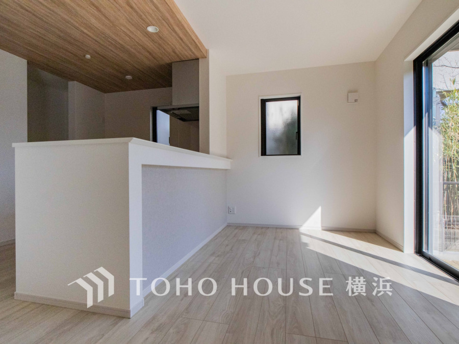 自然光が差し込む明るいリビング。木目天井が温かみを演出し、開放的な空間が広がります。