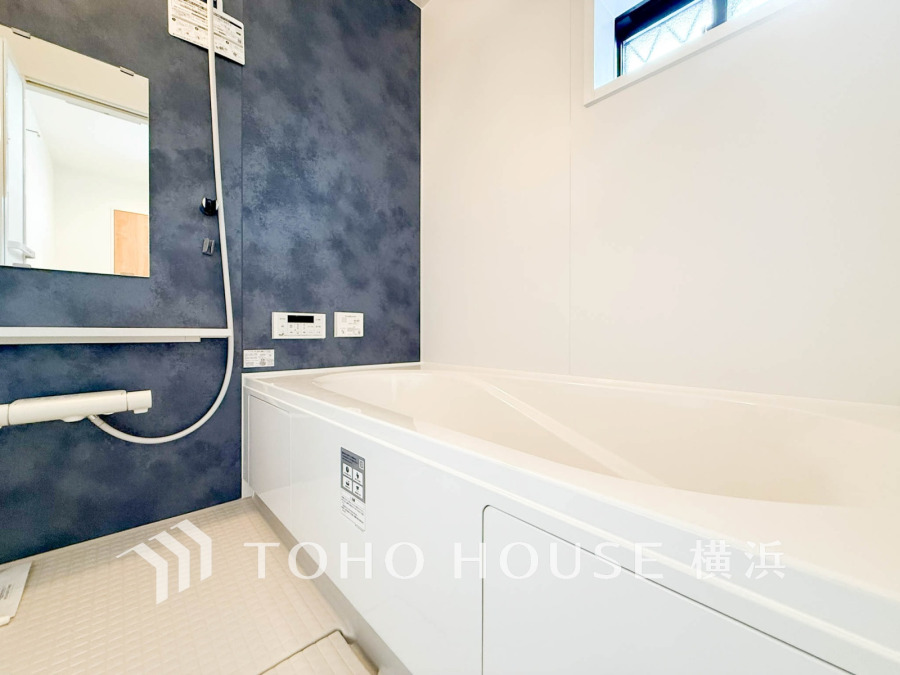 落ち着いたネイビーの壁がアクセントの清潔感あるバスルーム。快適なバスタイムを演出します。