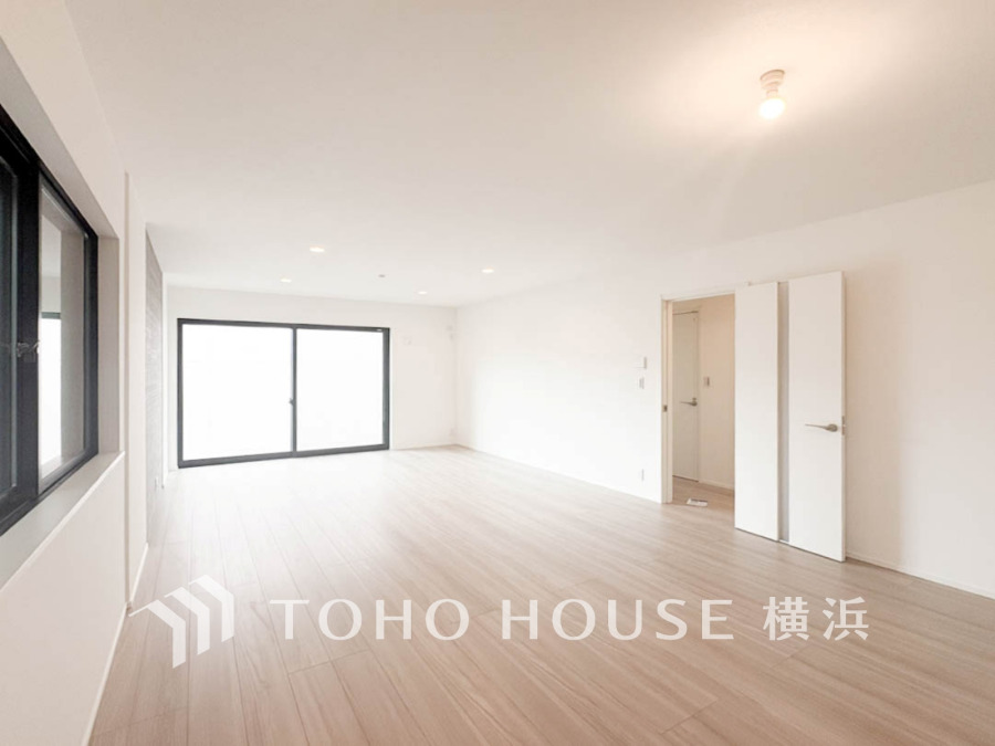 明るい光が差し込む広々としたリビング。シンプルでナチュラルな内装が心地よい空間を演出します。