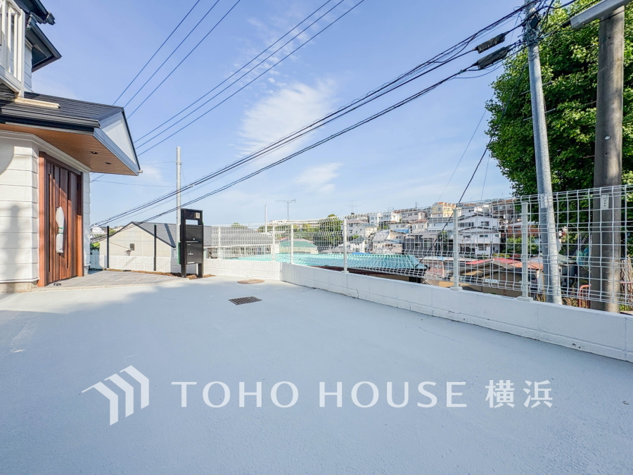 広々とした駐車スペースがあり、明るく開放的な住まいの玄関前。周辺の街並みも見渡せます。