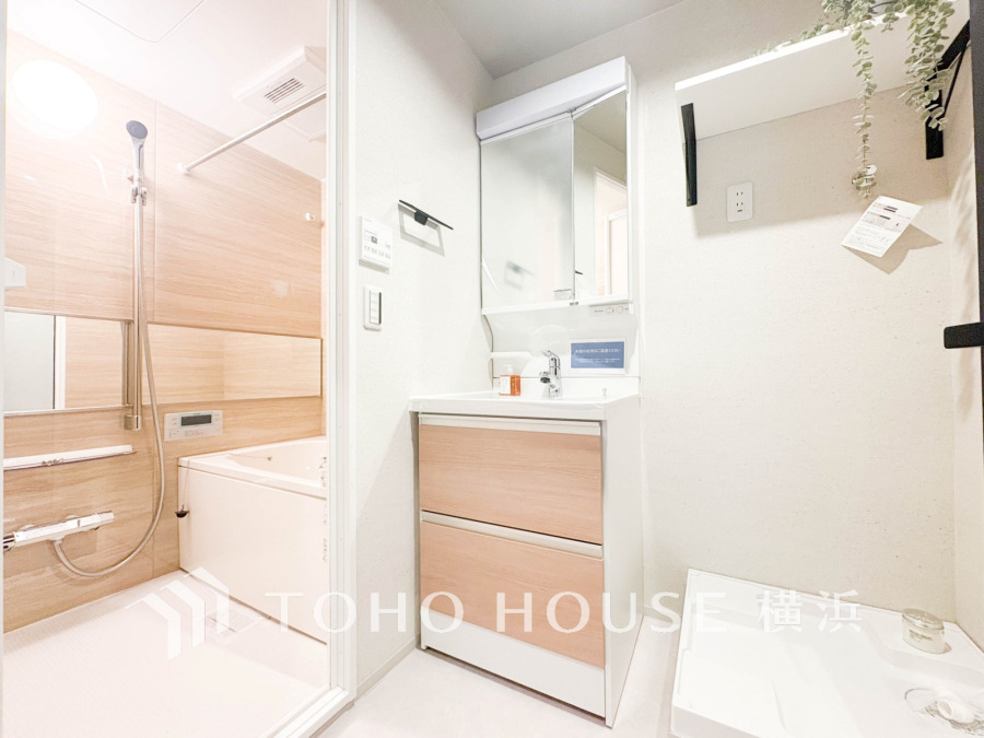 清潔感あふれる洗面所とバスルーム。木目調のパネルが温かみを演出し、ゆったりとした空間です。