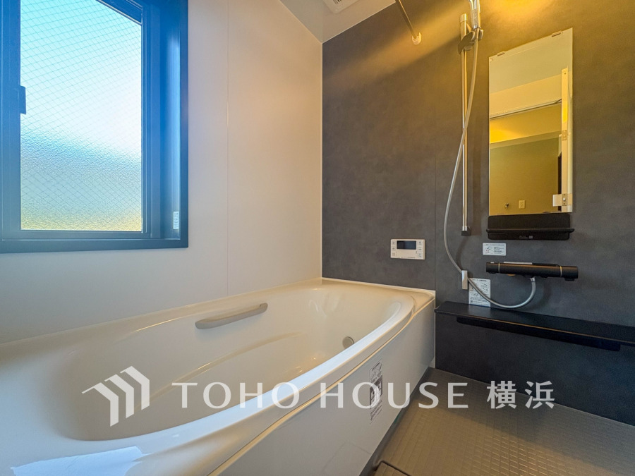 落ち着いた色調の壁がアクセントの、窓付きで明るい快適なバスルームです。ゆったりと寛げます。