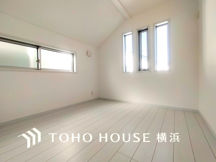 明るい自然光が差し込む、シンプルで清潔感あふれる白基調の快適な居室空間です。