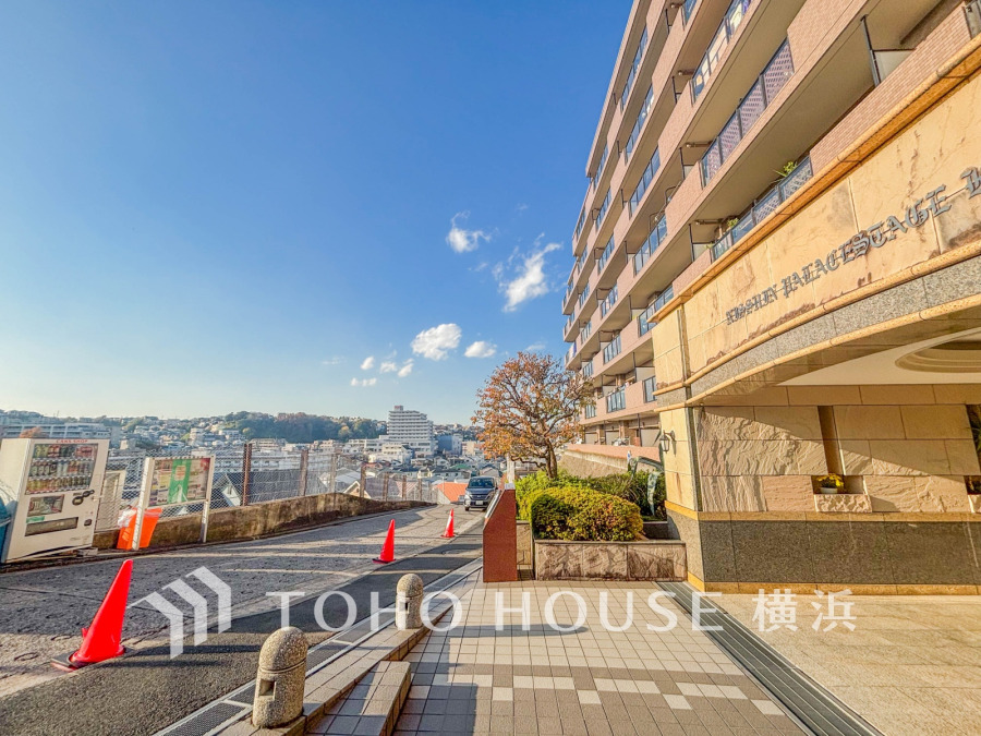 陽当たり良好な高台のマンション外観。開放的な眺望と落ち着いたエントランスが魅力です。