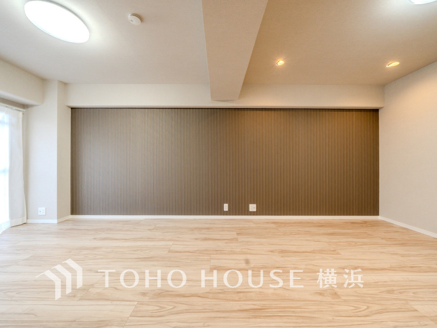 シンプルで落ち着いたアクセントクロスが魅力の、明るく広々としたリビング空間です。