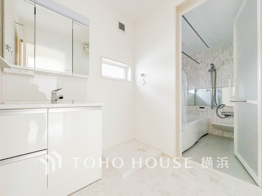 清潔感あふれるホワイト基調の洗面室。収納豊富な洗面台とゆったりした浴室で快適な毎日をサポートします。