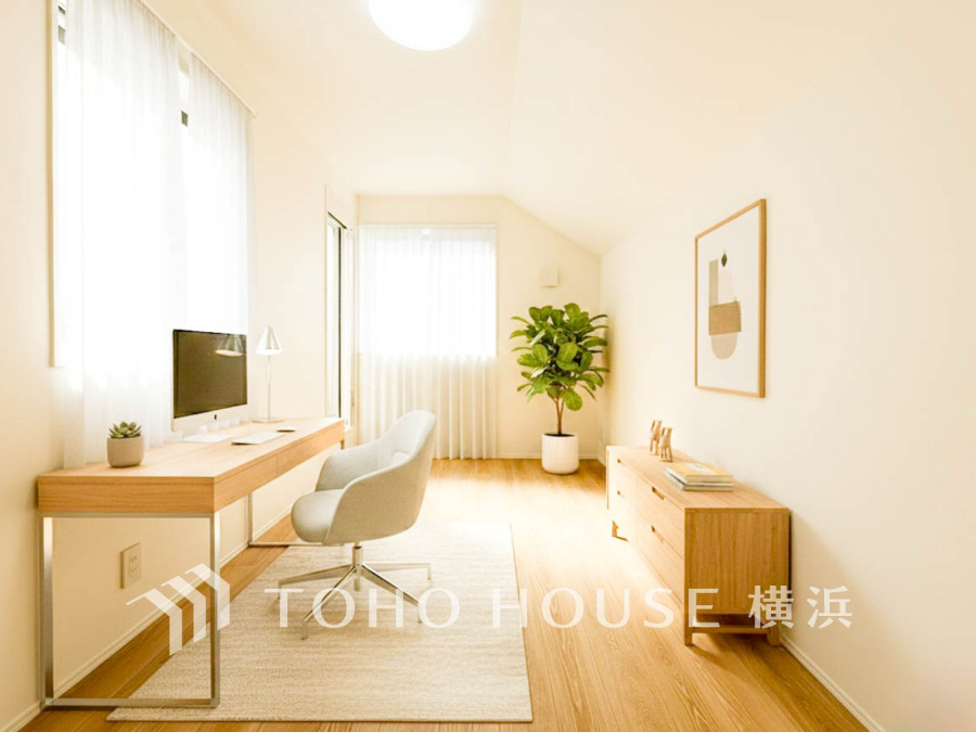 自然光がたっぷり入る明るい書斎。シンプルな家具と観葉植物が落ち着いた空間を演出します。