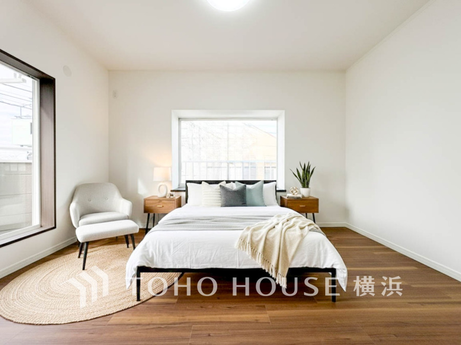 大きな窓から自然光が差し込む、シンプルで温かみのある落ち着いた寝室空間です。（家具・装飾品はAI加工です）