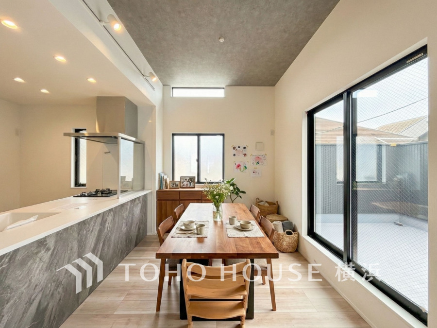 スタイリッシュな対面キッチンと一体感のあるダイニングスペース。キッチンにいるご家族との会話も楽しめる開放的な空間です。（家具はAI加工です）

