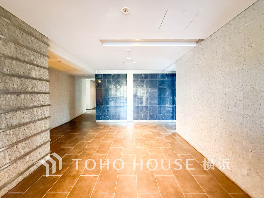 温かみのあるタイル床と落ち着いた壁面が調和した、洗練された共用エントランスホールです。