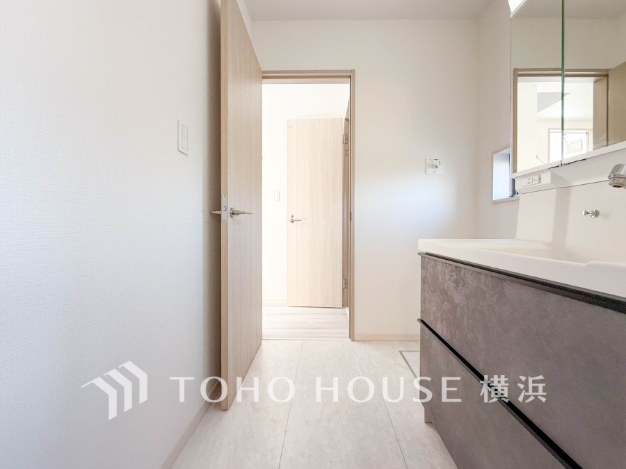 清潔感あふれる洗面所。大きな鏡と収納力のある洗面台で、毎日の身支度も快適に。自然光が差し込み明るい空間です。