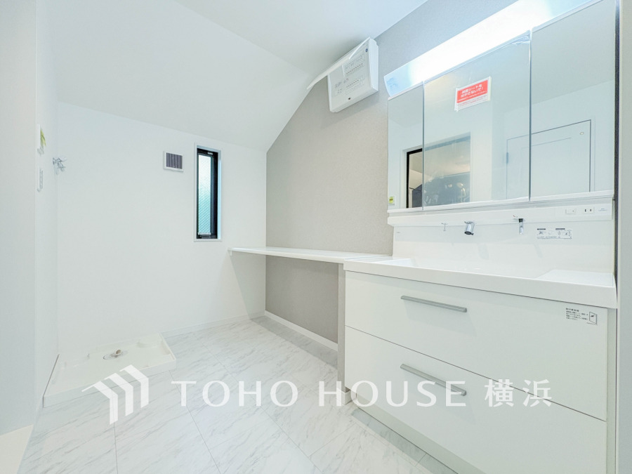 清潔感あふれる洗面室。広いカウンターと収納で家事もスムーズにこなせる快適な空間です。