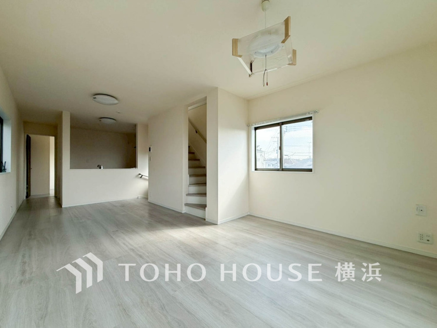 明るい窓から自然光が注ぐ、開放感あふれるリビングダイニング。白を基調とした清潔感ある空間です。