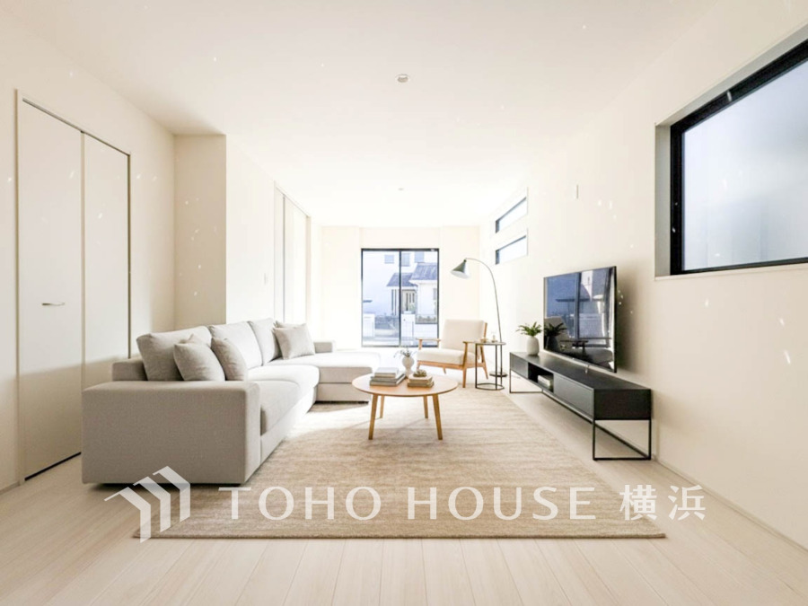 明るい自然光が差し込む、シンプルで広々としたリビングルーム。落ち着いた色合いで統一された空間です。（家具・装飾品はAI加工です）