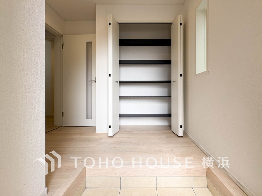 シンプルで清潔感ある玄関収納。棚付きで靴や小物もすっきり片付き、出入りもスムーズな設計です。