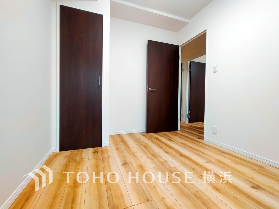 ナチュラルな木目床と落ち着いたダークブラウンの扉が調和するシンプルな居室空間です。収納も充実しています。