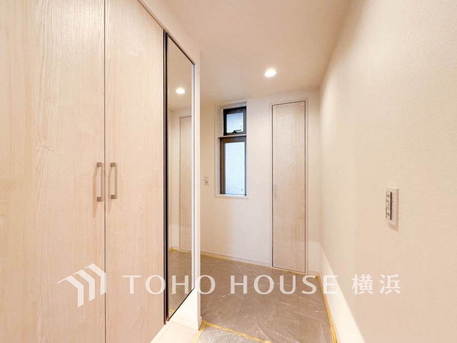 豊富な収納を確保した玄関スペース。便利な大型のミラーのついたシューズボックスを設置。
