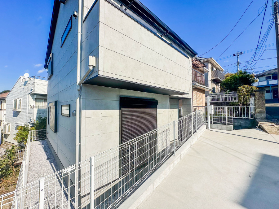 スタイリッシュなコンクリート打ち放しの外観。広々とした駐車スペースと安全なフェンスで快適な暮らしを実現します。