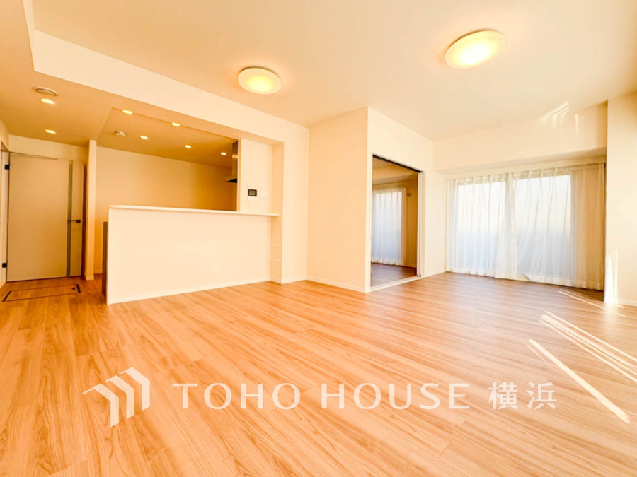 明るい光が差し込む広々リビング。オープンキッチンで家族の会話が弾む快適空間です。