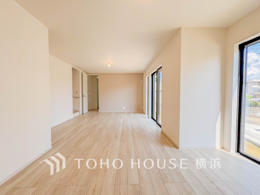 明るい自然光が差し込む広々としたリビングは、ナチュラルな木目調フローリングで温かみある空間を演出します。