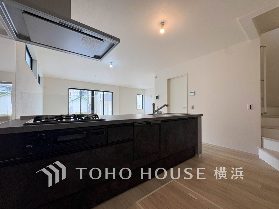 スタイリッシュな対面キッチンが開放的なリビングと一体化し、家族の会話が弾む快適な空間を演出します。