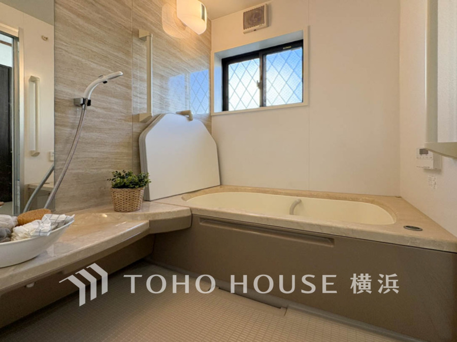 明るい窓から光が差し込む、清潔感あふれる浴室です。ゆったりとした浴槽で、家族みんなの疲れを癒し、快適なバスタイムをお楽しみください。