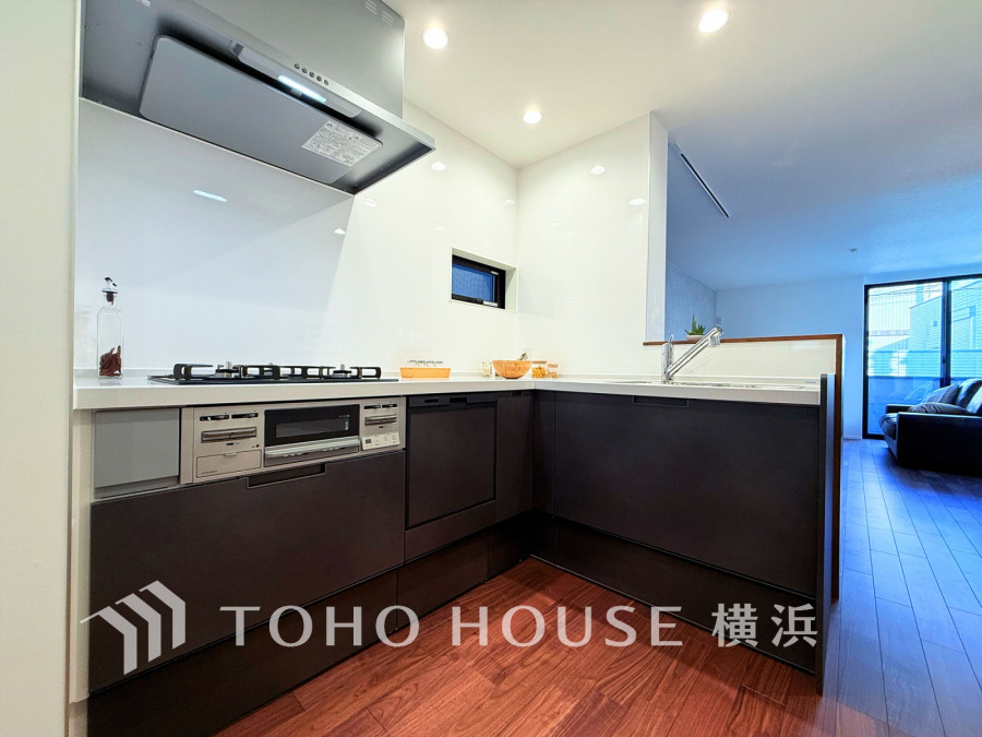 スタイリッシュなL字型キッチンは広々とした作業スペースで、家族との会話も楽しめる開放的な設計です。