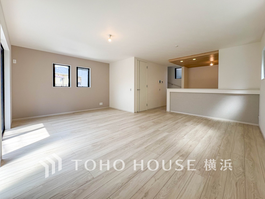 明るい光が差し込む広々リビング。木目調の天井が温かみを演出し、快適なくつろぎ空間を実現しています。