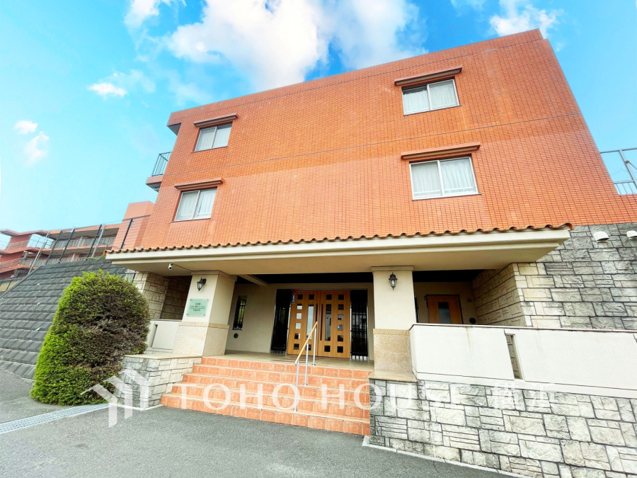 温かみのあるタイル外壁と石造りのエントランスが調和した上質なマンション。