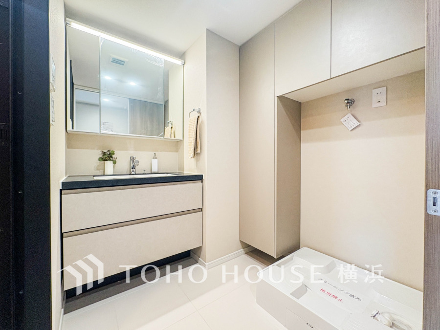 収納豊富な洗面台とミラーキャビネットで、家族の身支度もスムーズに。洗濯機置き場も確保され、家事効率を高める洗練された空間です。