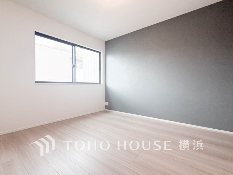 シンプルで落ち着いたアクセントクロスが映える、自然光がたっぷり入る明るい洋室です。