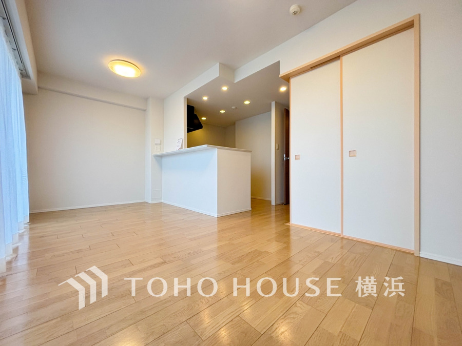 明るい自然光が差し込む、開放感あふれるリビング。使いやすいカウンターキッチンと収納スペースも充実しています。