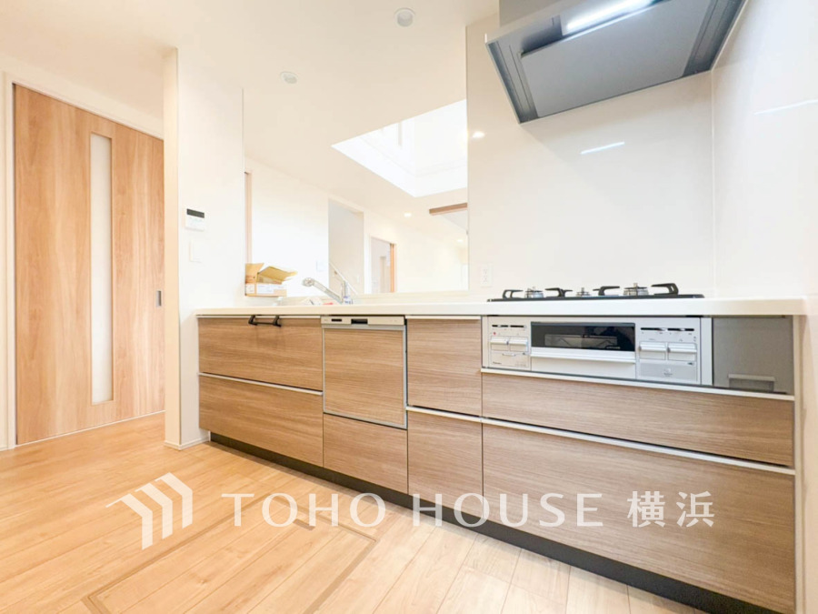 木目調の収納が美しい、明るく開放的な対面式キッチン。家族との会話を楽しみながら調理ができます。