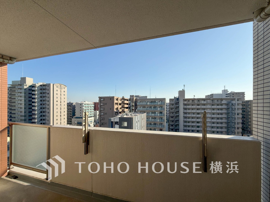 開放感あふれるバルコニーから、周囲のビル群と青空を一望できる心地よい住空間です。