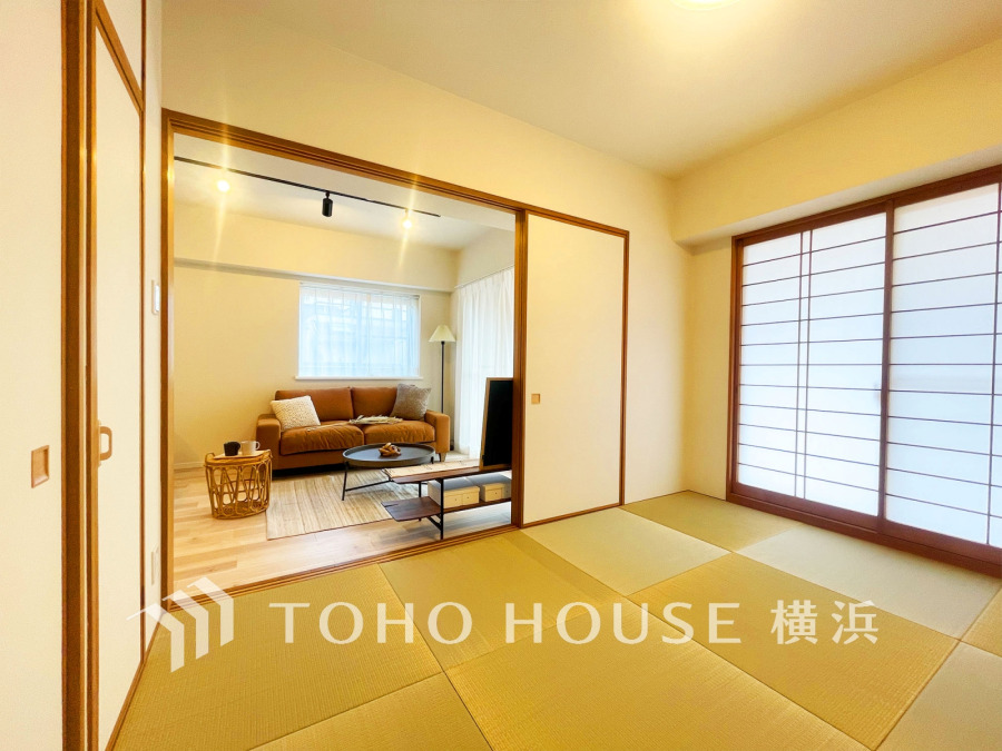 障子から柔らかな光が差し込む和室と、落ち着いたリビングが調和した寛ぎの空間です。