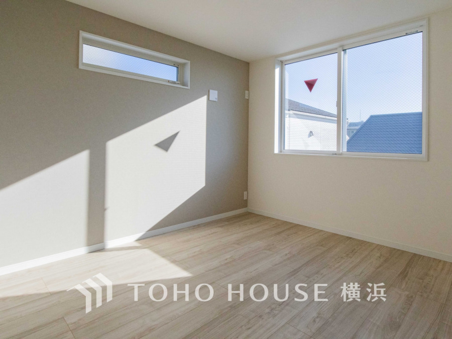 明るい自然光が差し込む、シンプルで落ち着いた色調の居室。快適な住空間を演出します。