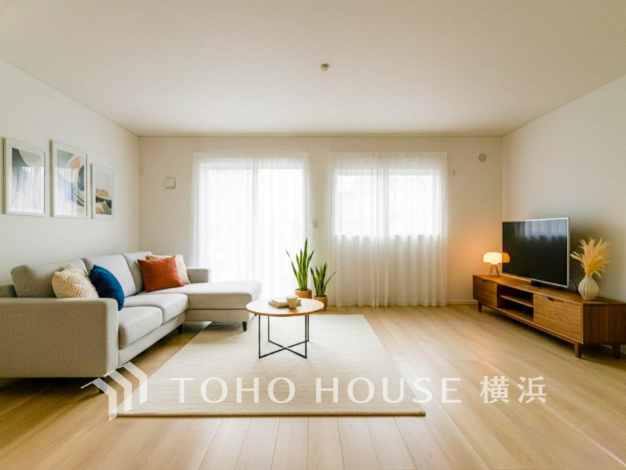 自然光がたっぷり入る明るいリビング。シンプルで温かみのあるインテリアが心地よい空間を演出します。（家具はAI加工です）