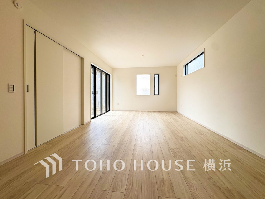 明るい自然光が差し込む広々としたリビング。ナチュラルな木目調フローリングで温かみのある空間です。