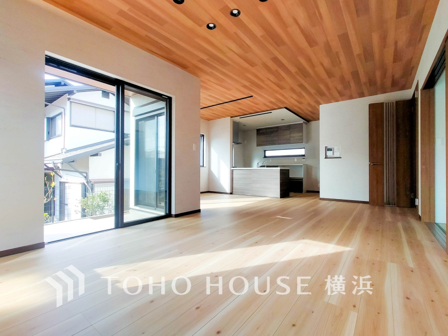 木目天井と広々とした開放感あるリビング。大きな窓から自然光がたっぷり入り、明るく快適な空間を演出します。