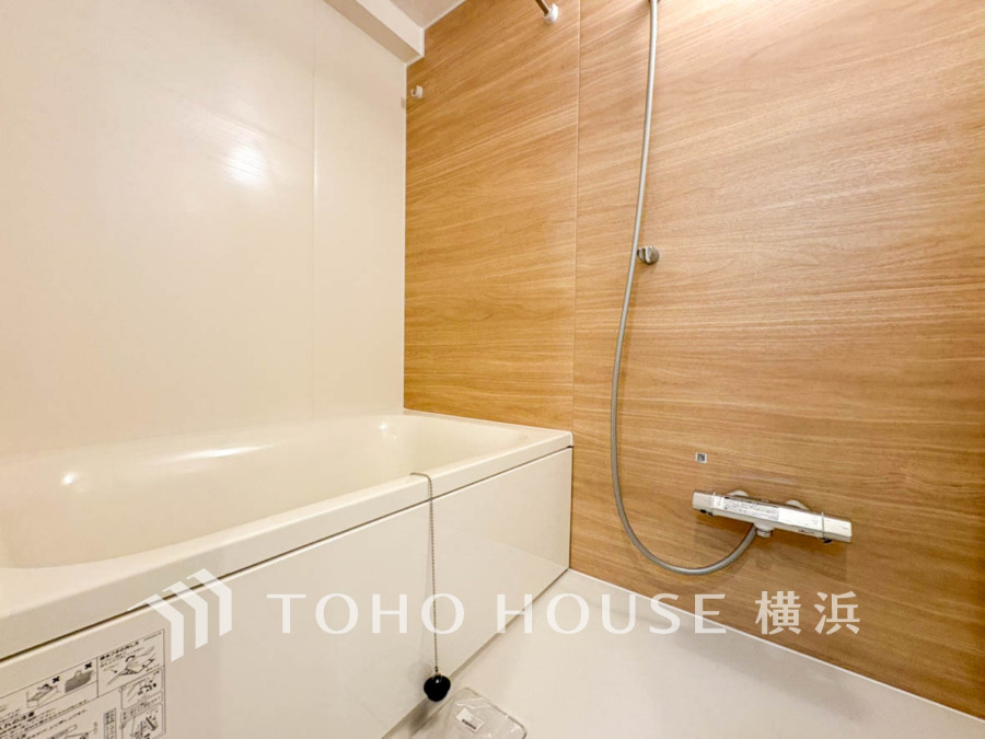 木目調の壁が温かみを演出する、清潔感あふれるシンプルなバスルームです。ゆったり寛げる浴槽付き。