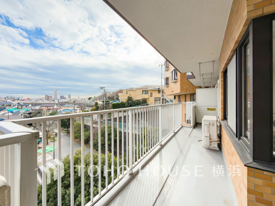 広々としたバルコニーから街並みと緑を一望でき、心地よい風と光を感じられる快適な空間です。