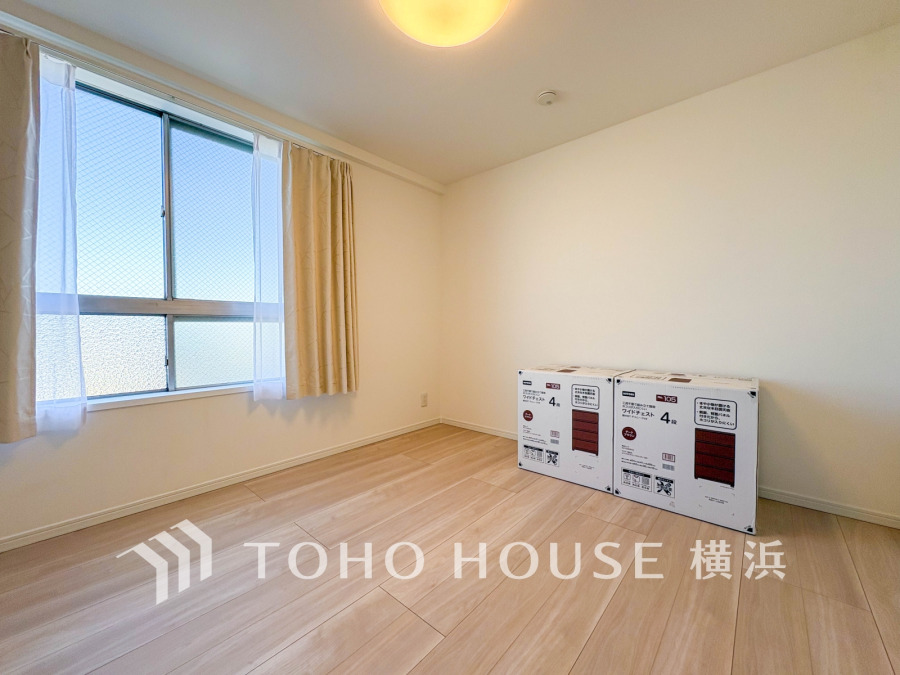 明るい自然光が差し込む、シンプルで清潔感のある洋室。収納家具の設置も可能です。