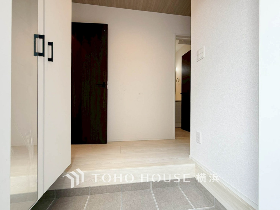 シンプルで清潔感のある玄関スペース。大容量の収納と段差の少ない設計で使い勝手良好です。