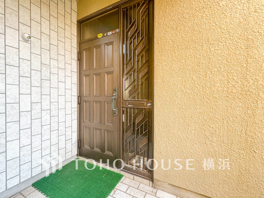 温かみのあるブラウンの玄関ドアと落ち着いた壁面が調和した、安心感のある玄関スペースです。