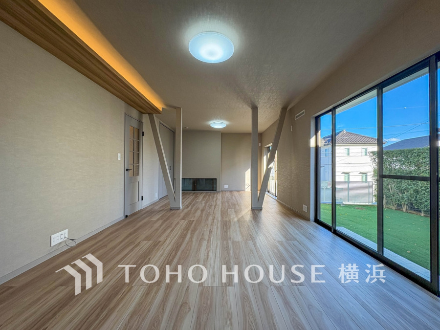 大きな窓から自然光が差し込む明るいリビング。木目調の床が温かみを演出する快適な空間です。